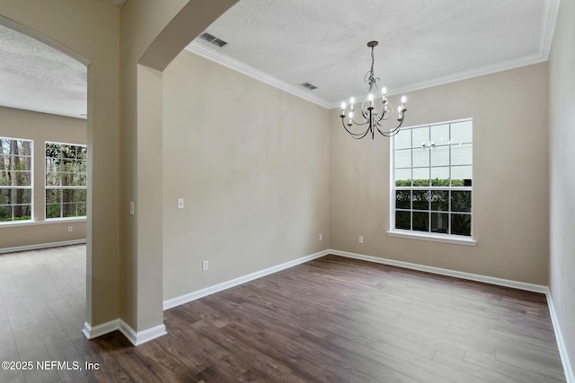 spare room featuring baseboards, visible vents, arched walkways, dark wood finished floors, and a textured ceiling