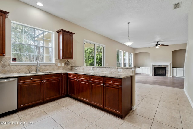 kitchen featuring light tile patterned floors, visible vents, backsplash, stainless steel dishwasher, and a sink