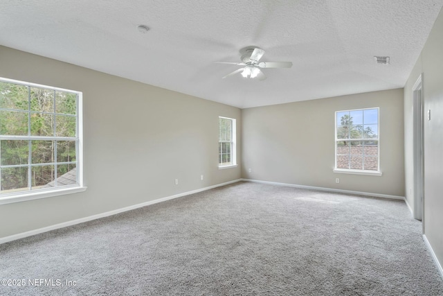 unfurnished room with ceiling fan, plenty of natural light, visible vents, and carpet