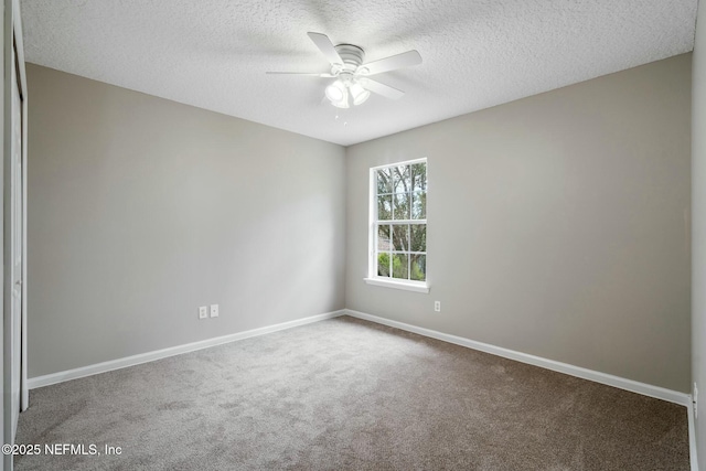 unfurnished room featuring carpet, baseboards, ceiling fan, and a textured ceiling