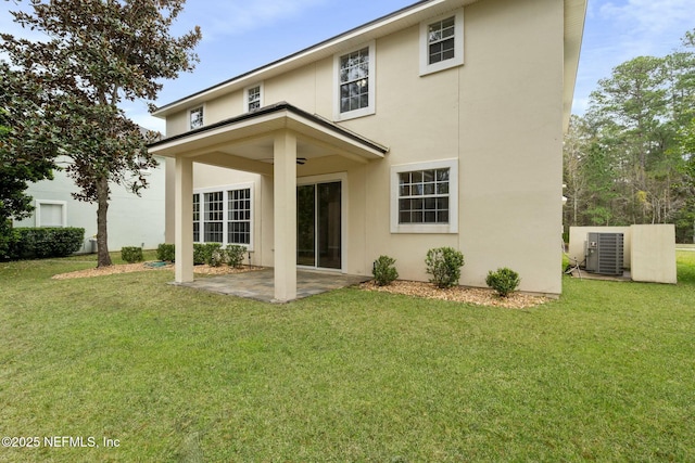 rear view of property with central air condition unit, a patio area, stucco siding, and a yard