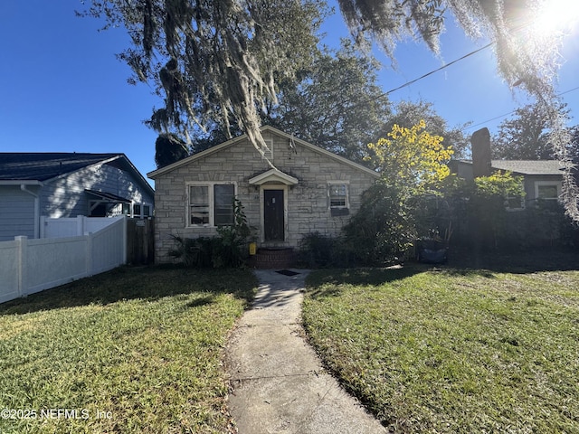 bungalow with a front yard and fence