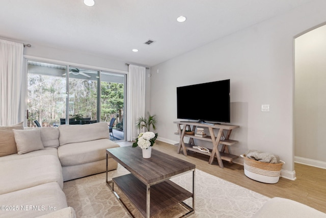 living room with recessed lighting, wood finished floors, visible vents, and baseboards