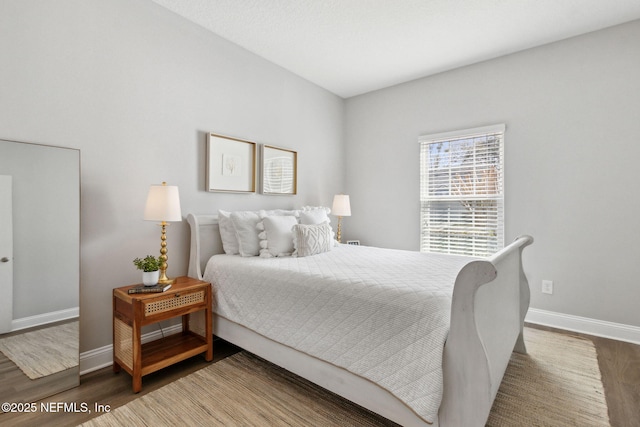 bedroom featuring baseboards and wood finished floors