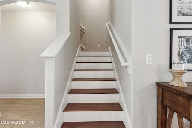 stairs with wood finished floors and baseboards