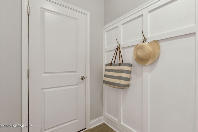 mudroom featuring baseboards and dark wood-type flooring