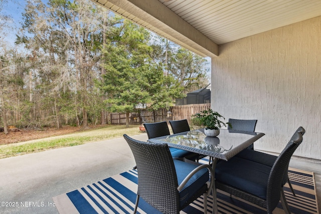 view of patio with outdoor dining space and fence