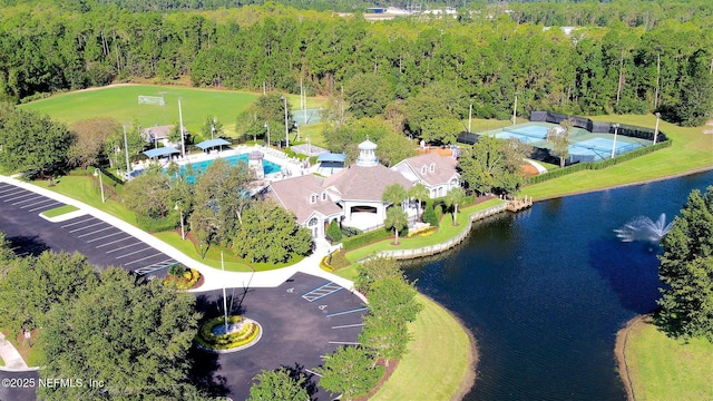 birds eye view of property with a water view and a wooded view