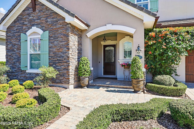 entrance to property featuring stone siding and stucco siding