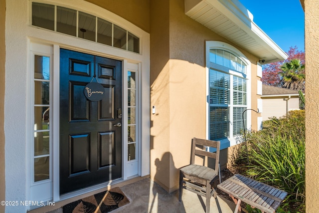 view of exterior entry featuring stucco siding