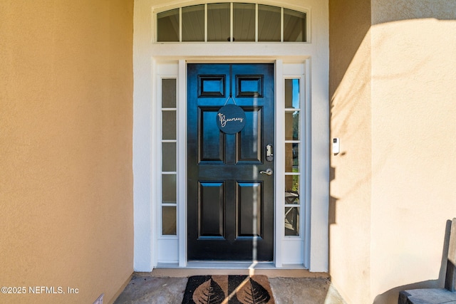 entrance to property with stucco siding