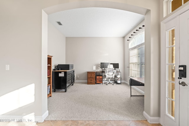 carpeted home office with baseboards and arched walkways