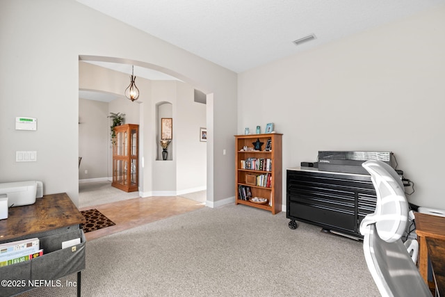 sitting room with baseboards, arched walkways, and carpet flooring