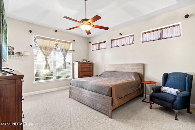 carpeted bedroom with ceiling fan and baseboards