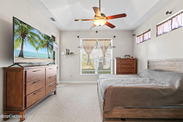 bedroom with light colored carpet, ceiling fan, visible vents, and baseboards