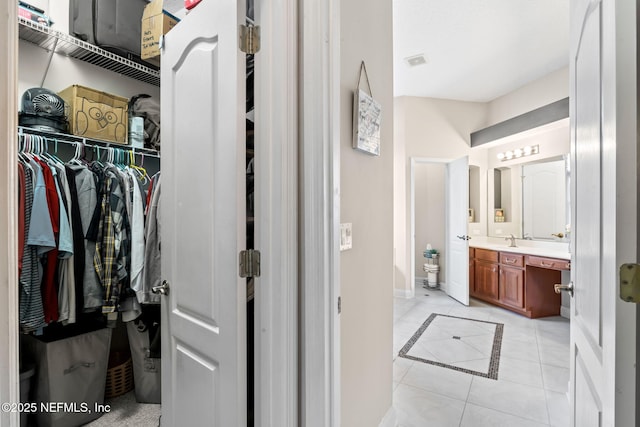 bathroom featuring visible vents, a spacious closet, vanity, tile patterned flooring, and baseboards