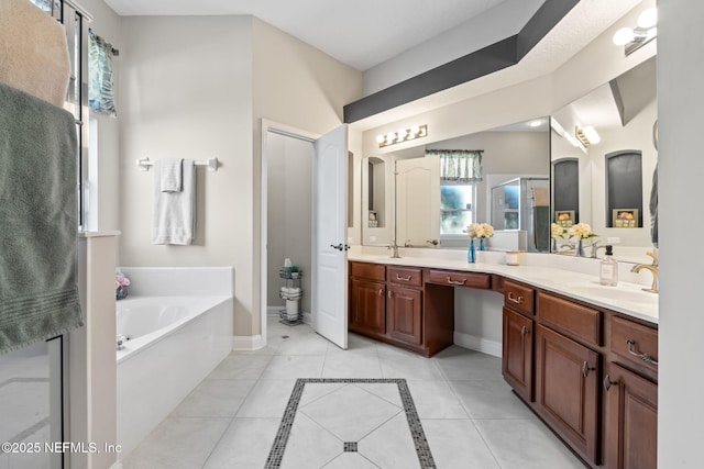 bathroom featuring double vanity, baseboards, a garden tub, tile patterned flooring, and a sink