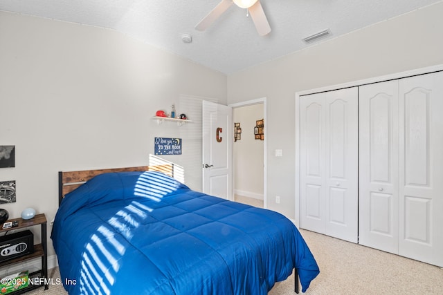 bedroom with carpet floors, lofted ceiling, a closet, visible vents, and a ceiling fan