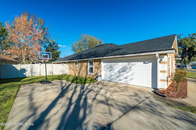 view of front of house featuring roof with shingles, a front yard, fence, a garage, and driveway