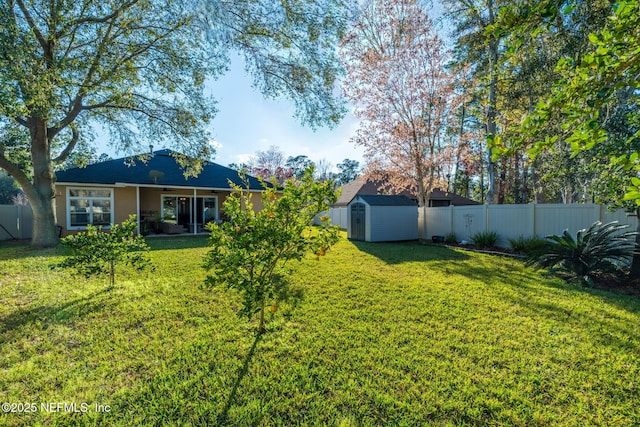 view of yard featuring an outbuilding, a storage unit, and a fenced backyard