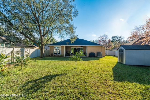 back of property featuring a shed, a lawn, a fenced backyard, and an outbuilding