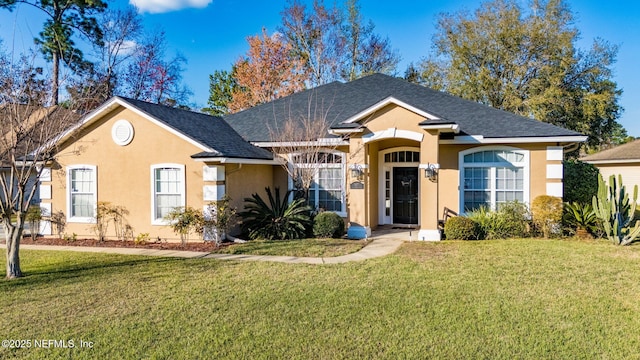 ranch-style house featuring a shingled roof, a front yard, and stucco siding