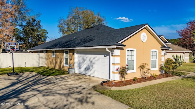 view of property exterior featuring a garage, concrete driveway, fence, and a lawn