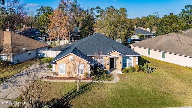 ranch-style home with fence, a front lawn, and stucco siding