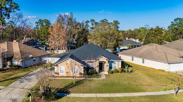 ranch-style home featuring concrete driveway and a front yard