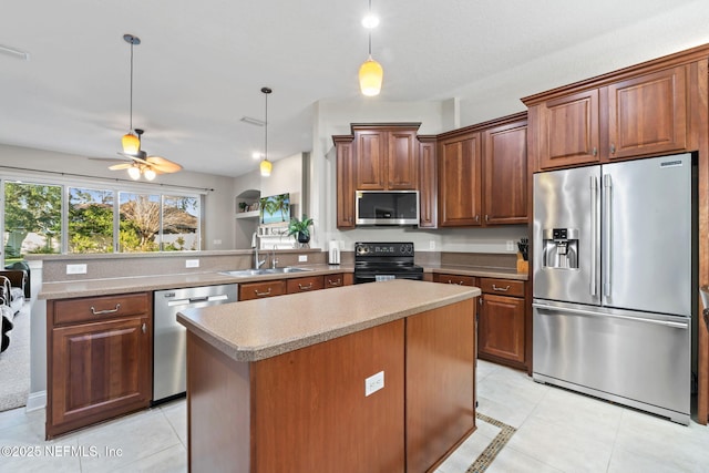 kitchen featuring light tile patterned floors, a sink, hanging light fixtures, appliances with stainless steel finishes, and a center island