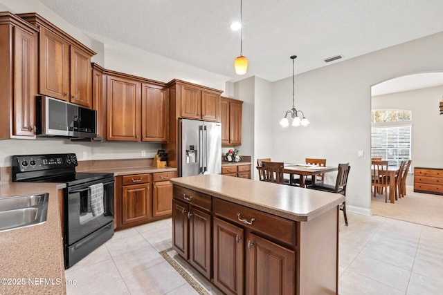 kitchen with arched walkways, light countertops, visible vents, appliances with stainless steel finishes, and light tile patterned flooring