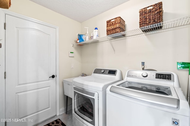 laundry area with a textured ceiling, laundry area, and washer and clothes dryer