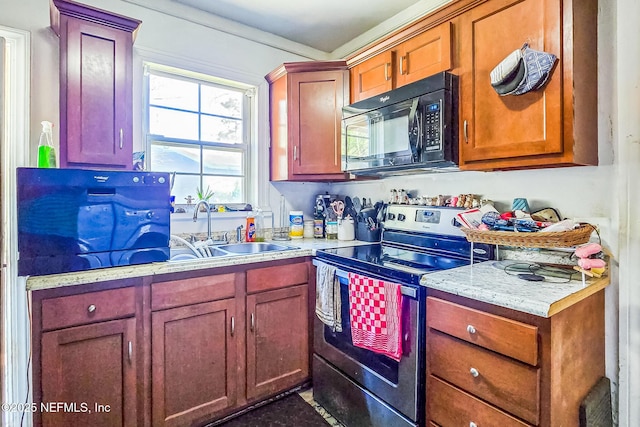 kitchen featuring electric stove, black microwave, light countertops, and a sink