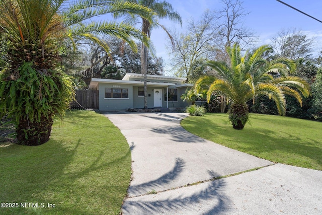 view of front of property featuring driveway, a front lawn, and fence