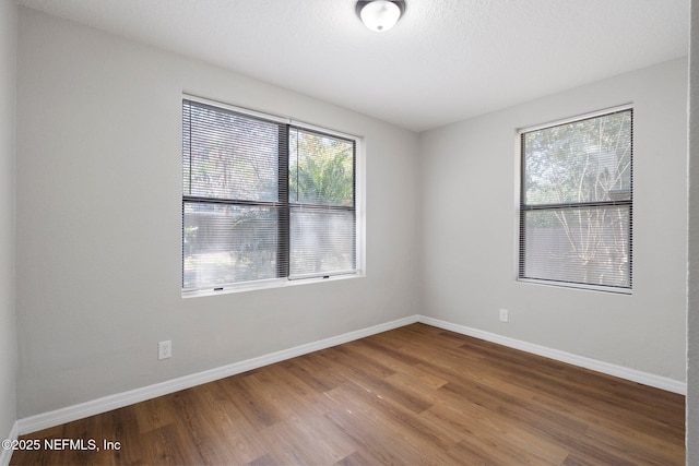 empty room with baseboards and wood finished floors