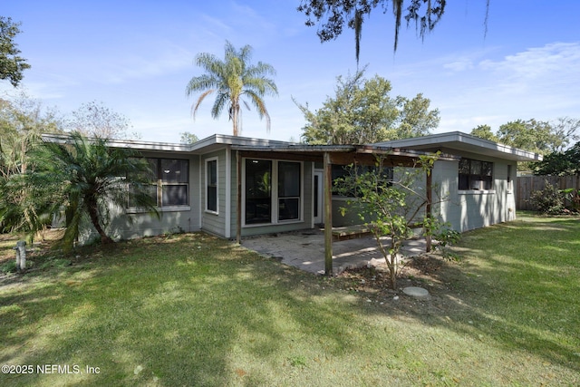 back of property with a patio area, fence, a sunroom, and a yard