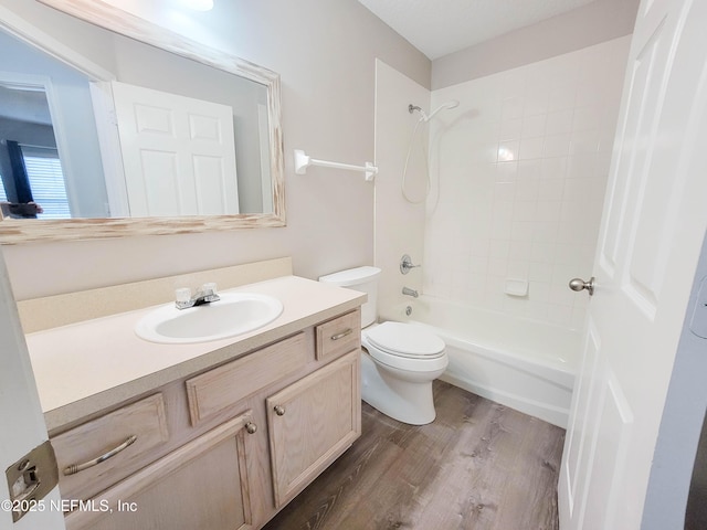 bathroom featuring toilet, shower / tub combination, wood finished floors, and vanity