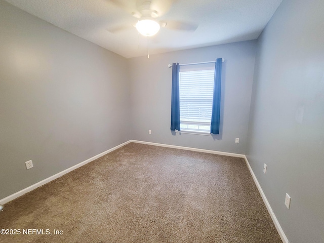 carpeted empty room with a ceiling fan and baseboards