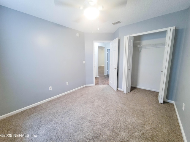 unfurnished bedroom with baseboards, a closet, visible vents, and carpet flooring