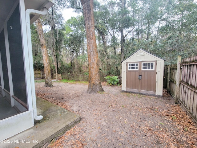 view of yard featuring a fenced backyard, an outdoor structure, and a storage unit