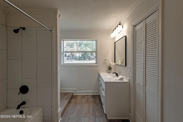 bathroom featuring wood finished floors, a textured ceiling, vanity, a closet, and shower / bathing tub combination