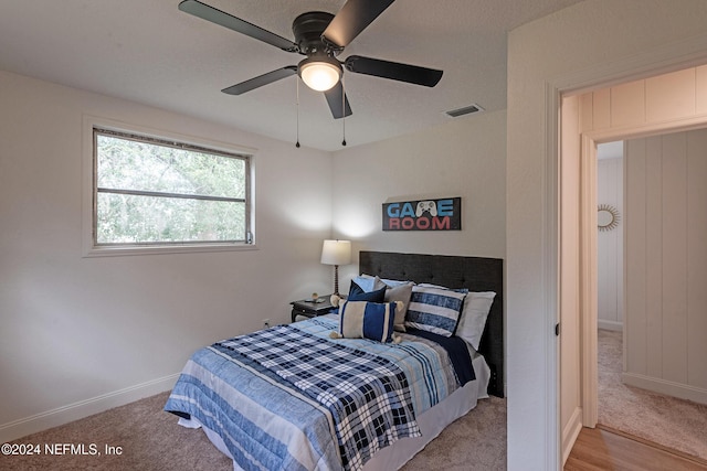 carpeted bedroom featuring a ceiling fan, visible vents, and baseboards