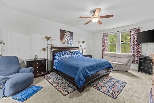 carpeted bedroom featuring ceiling fan and a textured ceiling