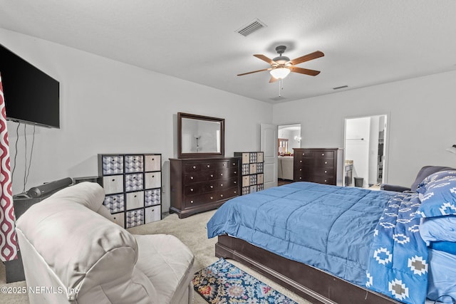 carpeted bedroom with ceiling fan, a textured ceiling, visible vents, and ensuite bathroom