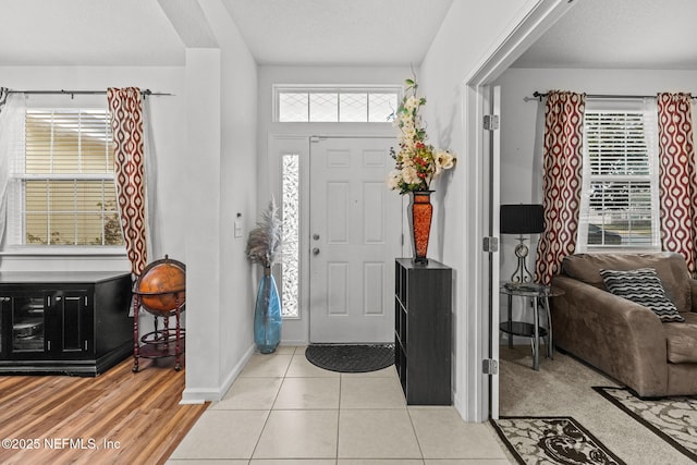 entrance foyer with plenty of natural light, baseboards, and light tile patterned floors