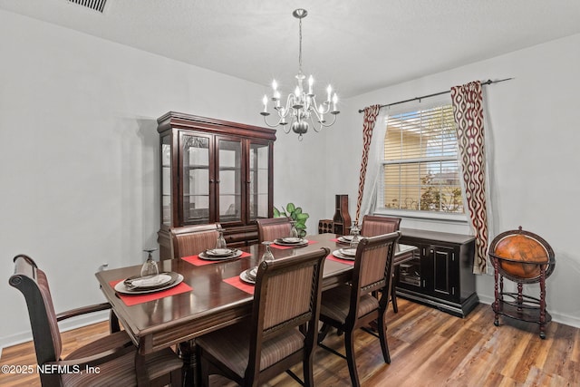 dining room featuring a notable chandelier, baseboards, and light wood-style floors