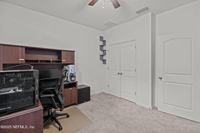 carpeted office featuring visible vents, ceiling fan, a textured ceiling, and baseboards