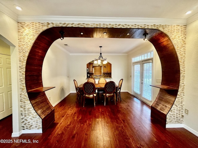 dining room with french doors, crown molding, baseboards, and wood finished floors