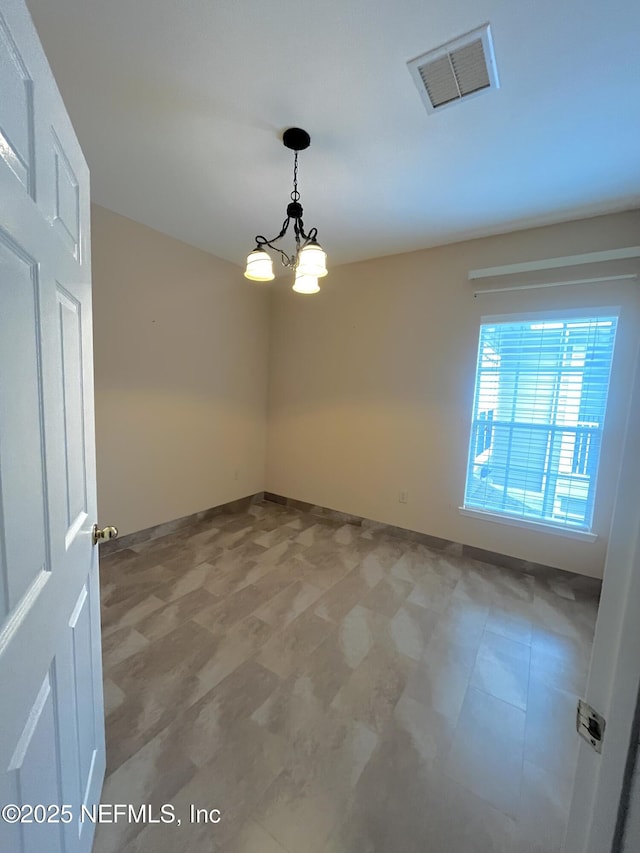 spare room with a chandelier and visible vents