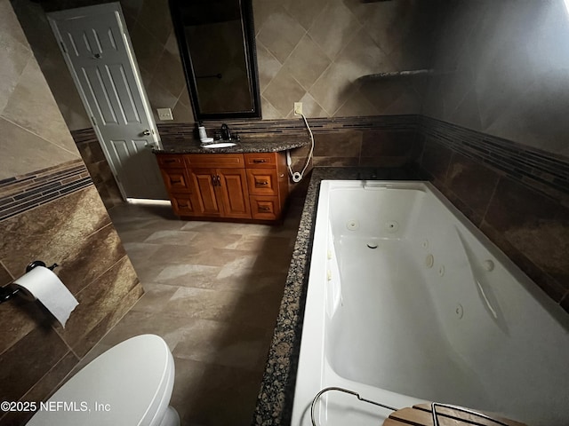 bathroom featuring tile walls, backsplash, toilet, vanity, and a jetted tub